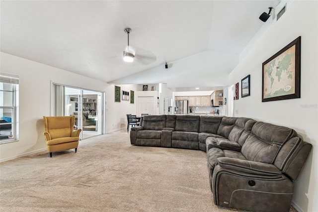 living room with baseboards, a ceiling fan, vaulted ceiling, and light carpet