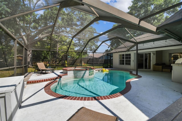 view of pool with glass enclosure, a pool with connected hot tub, and a patio area