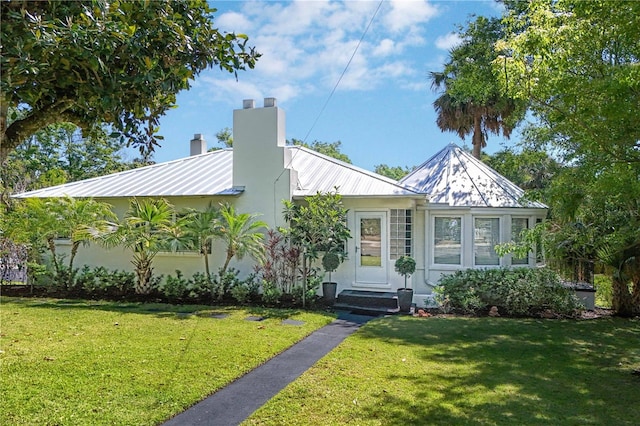 306 N Clayton St, Mount Dora, FL 32757 - view of front facade featuring a chimney, a front lawn, metal roof, and stucco siding