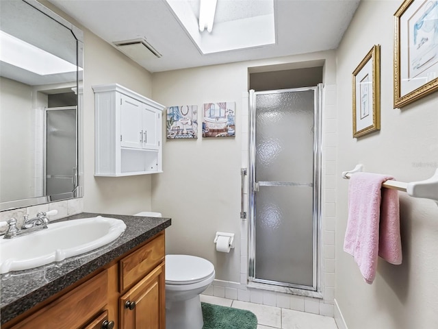 bathroom featuring toilet, a stall shower, and tile patterned floors