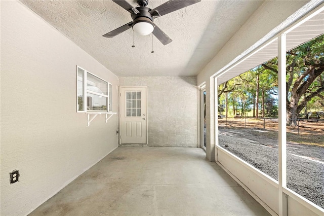 unfurnished sunroom with ceiling fan