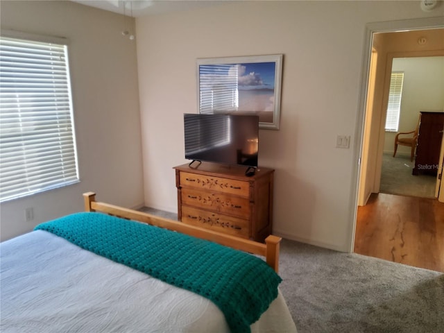 carpeted bedroom with baseboards and multiple windows