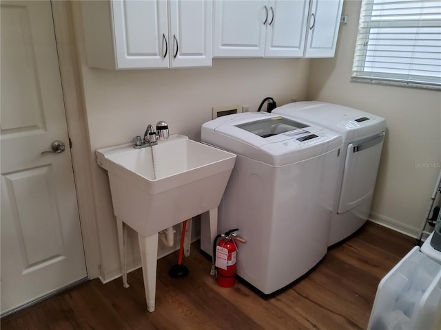 washroom with washer and dryer, cabinet space, and dark wood-style flooring