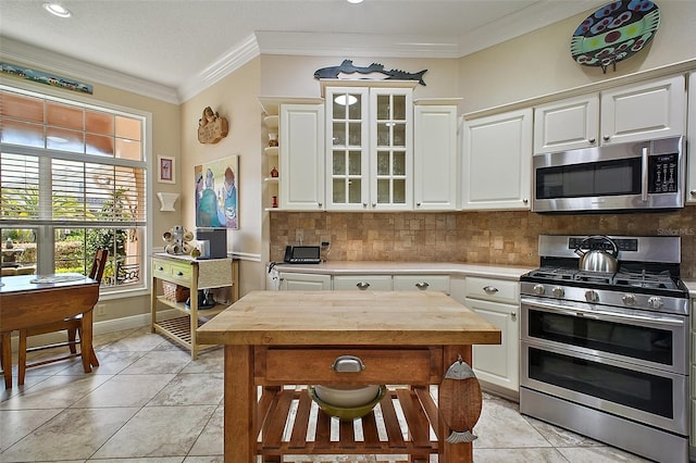 kitchen with white cabinets, stainless steel appliances, light tile patterned floors, wood counters, and tasteful backsplash