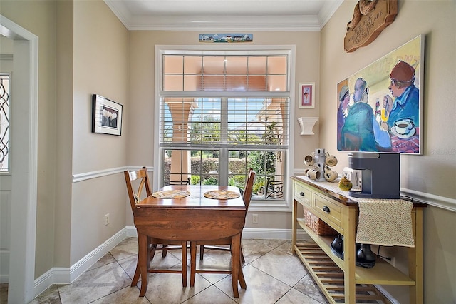 dining room featuring baseboards, ornamental molding, and light tile patterned floors