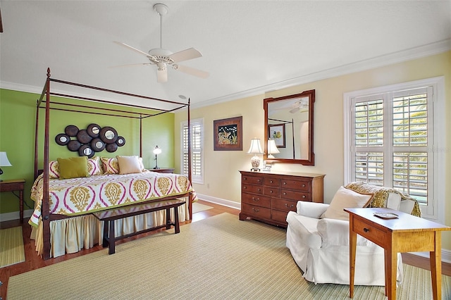 bedroom with wood finished floors, crown molding, baseboards, and multiple windows