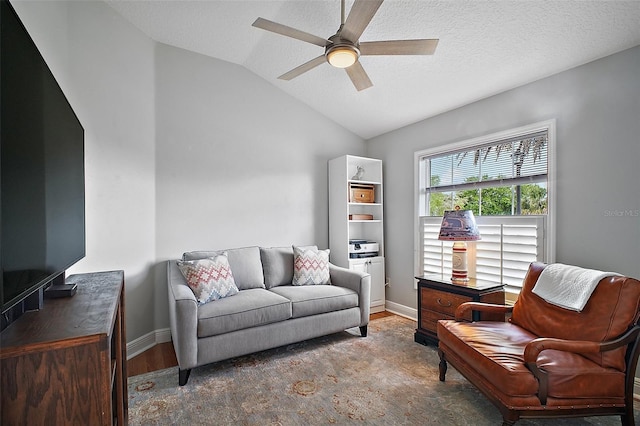 sitting room with baseboards, a ceiling fan, wood finished floors, and lofted ceiling