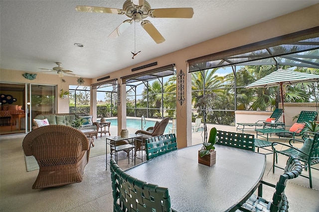 sunroom featuring a textured ceiling, a wealth of natural light, and ceiling fan