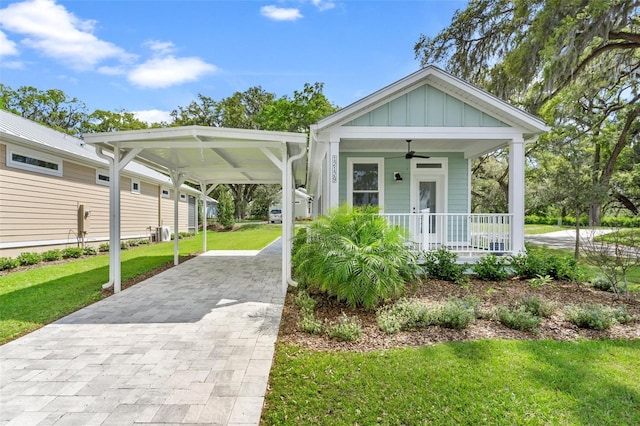 12129 Grand Oak Ln, Oxford, FL 34484 - view of front of property featuring a front lawn, driveway, a porch, ceiling fan, and board and batten siding