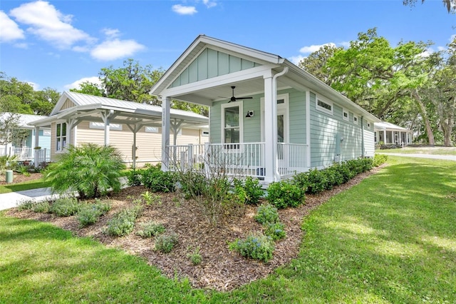 12129 Grand Oak Ln, Oxford, FL 34484 - view of front of house featuring a porch, a ceiling fan, board and batten siding, and a front yard