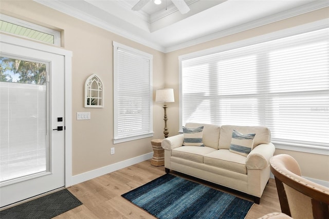 12129 Grand Oak Ln, Oxford, FL 34484 - living room featuring a raised ceiling, ornamental molding, light wood-type flooring, baseboards, and ceiling fan