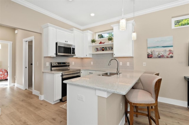 12129 Grand Oak Ln, Oxford, FL 34484 - kitchen with open shelves, a sink, a kitchen bar, a peninsula, and appliances with stainless steel finishes
