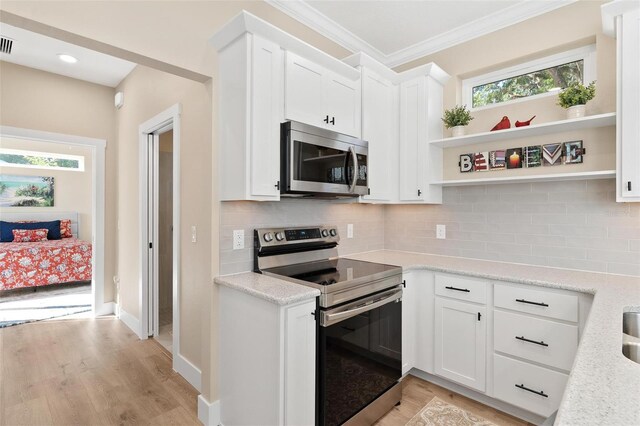 12129 Grand Oak Ln, Oxford, FL 34484 - kitchen featuring open shelves, backsplash, light wood-style floors, and stainless steel appliances