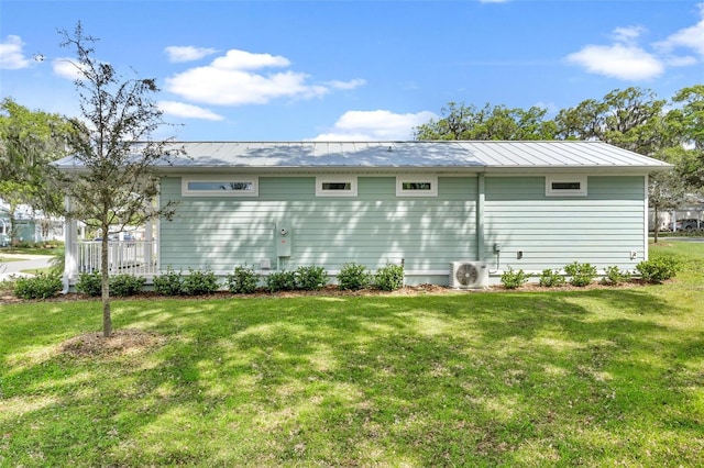 12129 Grand Oak Ln, Oxford, FL 34484 - rear view of property with a lawn, a standing seam roof, ac unit, and metal roof