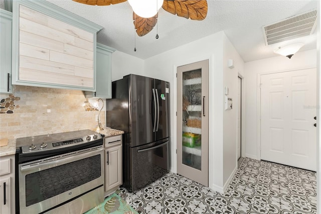kitchen with tasteful backsplash, ceiling fan, stainless steel appliances, baseboards, and visible vents