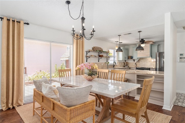 dining area featuring visible vents, baseboards, wood finished floors, and ceiling fan with notable chandelier