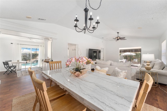 dining area featuring lofted ceiling, dark wood-style flooring, visible vents, and ceiling fan with notable chandelier