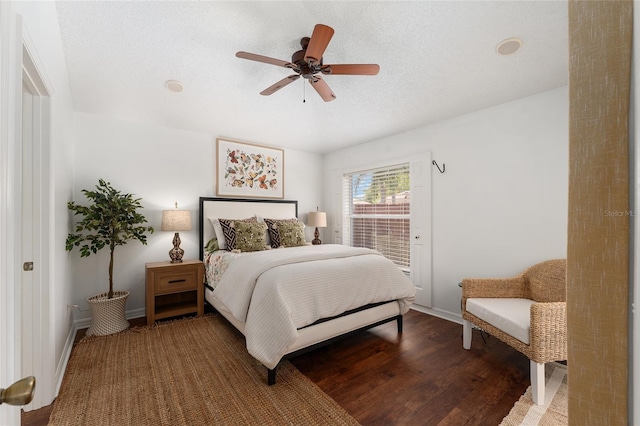 bedroom with wood finished floors, a textured ceiling, a ceiling fan, and baseboards