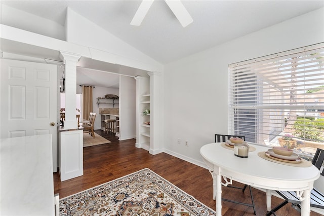 dining space with vaulted ceiling, wood finished floors, a ceiling fan, baseboards, and decorative columns