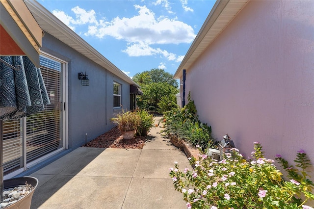 view of side of property featuring a patio area and stucco siding