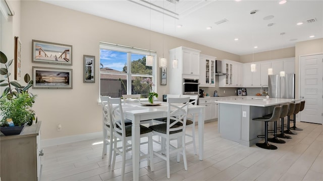 26516 Savage Cir, Howey In The Hills, FL 34737 - kitchen with light countertops, a kitchen bar, a sink, glass insert cabinets, and stainless steel appliances