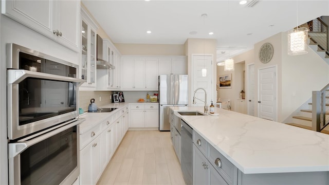 26516 Savage Cir, Howey In The Hills, FL 34737 - kitchen featuring stainless steel appliances, a kitchen island with sink, backsplash, light stone countertops, and white cabinetry