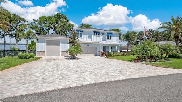 26516 Savage Cir, Howey In The Hills, FL 34737 - view of front of house with decorative driveway, board and batten siding, stone siding, and a water view