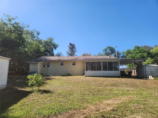 back of property with a storage shed, a sunroom, a lawn, and an outbuilding
