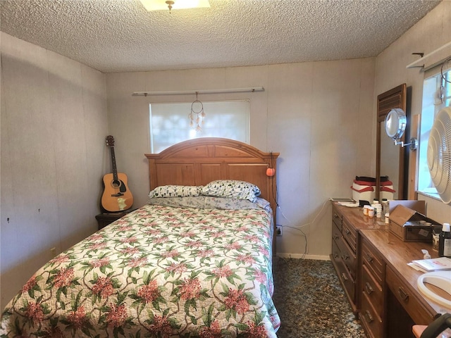 bedroom featuring a textured ceiling, a sink, and dark colored carpet