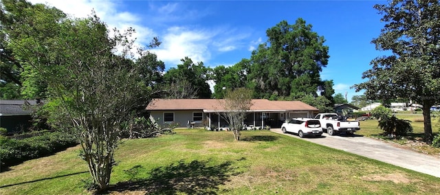 single story home featuring an attached garage, driveway, and a front lawn