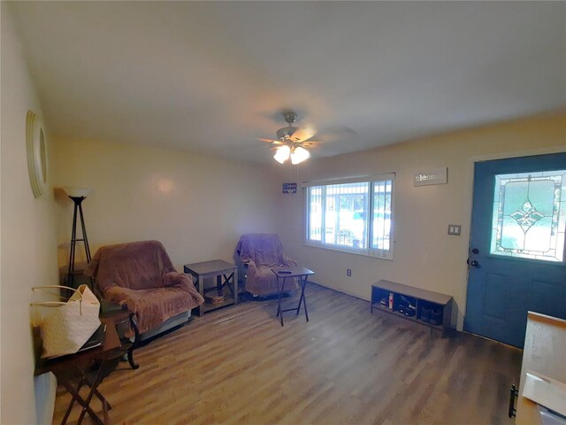 living area with wood finished floors and a ceiling fan