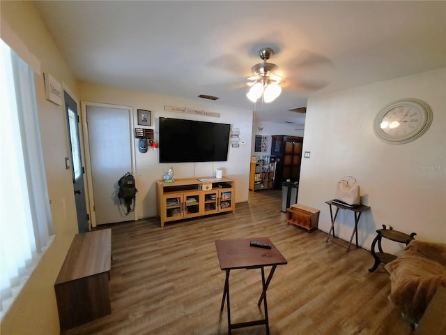 living room featuring visible vents, a ceiling fan, and wood finished floors