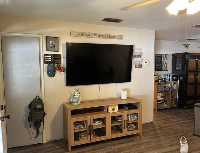 living area featuring wood finished floors, a ceiling fan, and visible vents