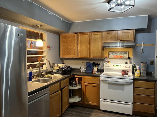 kitchen with dark wood finished floors, under cabinet range hood, stainless steel appliances, dark countertops, and a sink