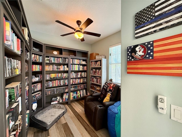 30554 Quince Ave, Eustis, FL 32736 - sitting room featuring wall of books, wood finished floors, ceiling fan, and a textured ceiling