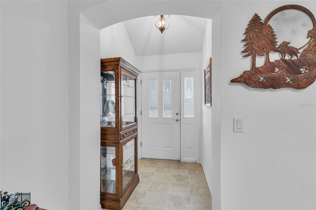 foyer with baseboards and arched walkways