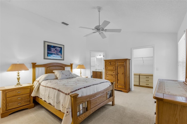 bedroom featuring visible vents, light carpet, a walk in closet, a closet, and ceiling fan