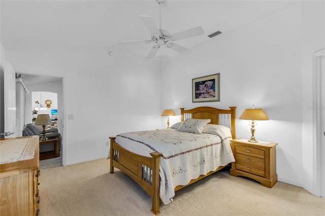 bedroom featuring lofted ceiling, visible vents, a ceiling fan, baseboards, and light colored carpet