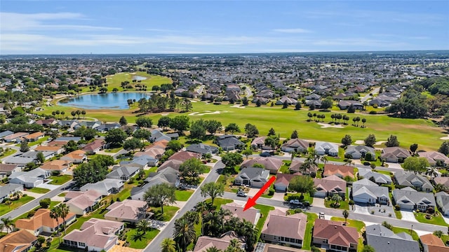 drone / aerial view with a residential view, golf course view, and a water view