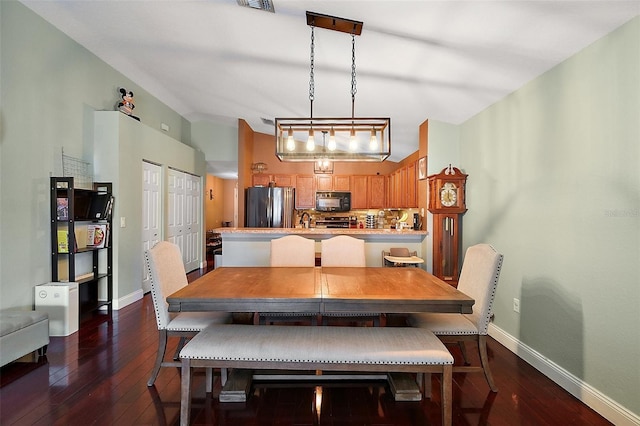 dining area featuring visible vents, baseboards, and dark wood finished floors
