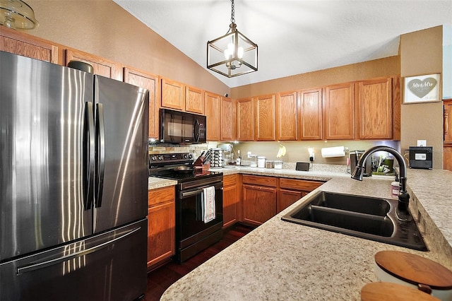 kitchen with black appliances, a sink, vaulted ceiling, and light countertops