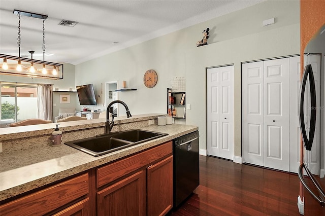 kitchen featuring a sink, stainless steel refrigerator, pendant lighting, dishwasher, and dark wood finished floors