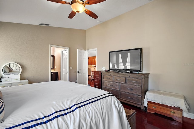 bedroom featuring dark wood finished floors, connected bathroom, visible vents, a ceiling fan, and lofted ceiling