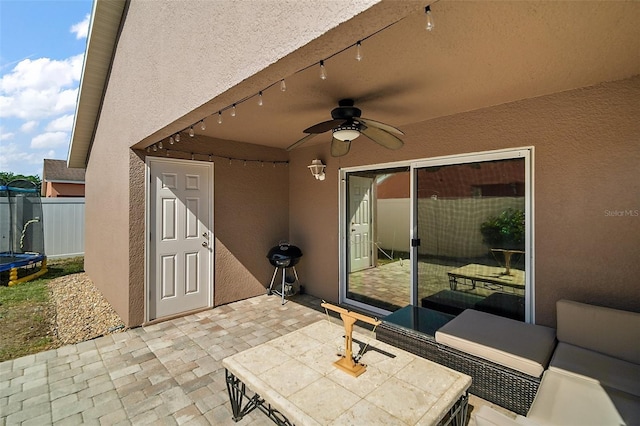 view of patio / terrace with fence, ceiling fan, and a trampoline