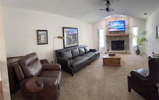 carpeted living area featuring a textured ceiling, vaulted ceiling, visible vents, ceiling fan, and a fireplace