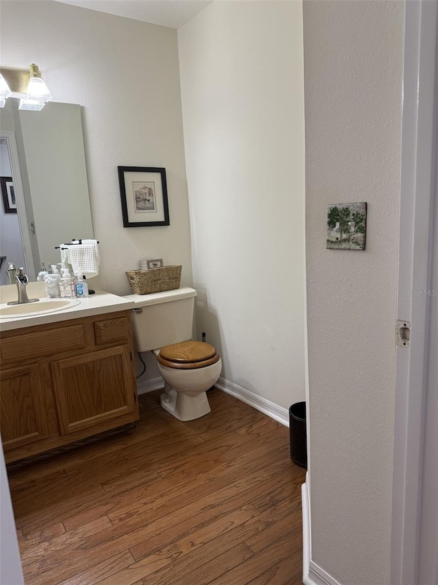 4941 Tradition Dr, Lakeland, FL 33812 - bathroom with vanity, baseboards, toilet, and wood finished floors
