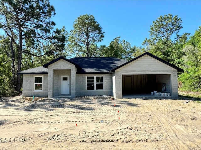 view of front of house featuring an attached garage and dirt driveway