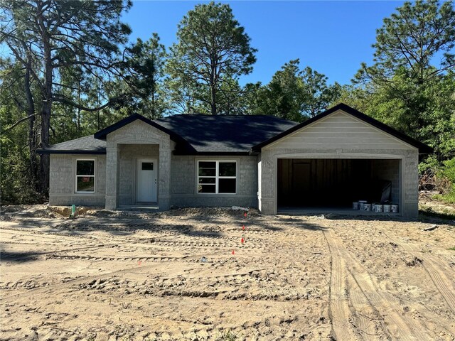 unfinished property with dirt driveway and an attached garage