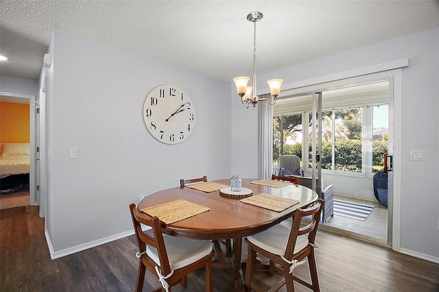 dining room with baseboards, a chandelier, wood finished floors, and a textured ceiling