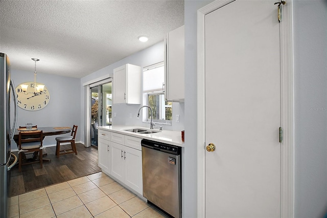 kitchen featuring a textured ceiling, appliances with stainless steel finishes, a notable chandelier, and a sink